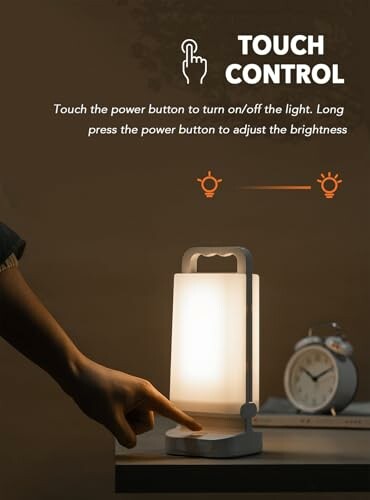 Person touching a modern touch control lamp on a table with an alarm clock.